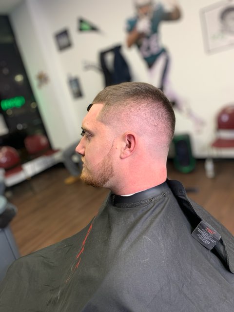 Man with fresh haircut, sitting in a modern, stylish barber shop.